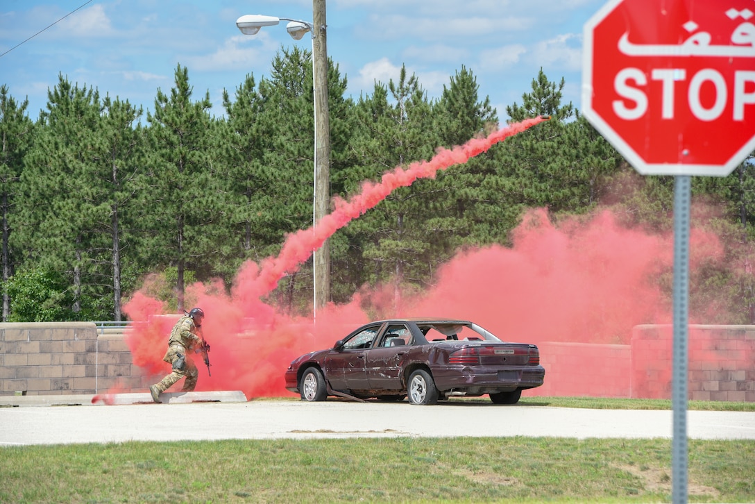 An Airman taking part in the Audacious Warrior Exercise throws a smoke grenade during a tactical training June 28, 2018, on Fort McCoy, Wisconsin. Airmen were split into two teams and used tactical techniques to reach a goal while training with simunitions. (U.S. Air National Guard photo by Airman Cameron Lewis)