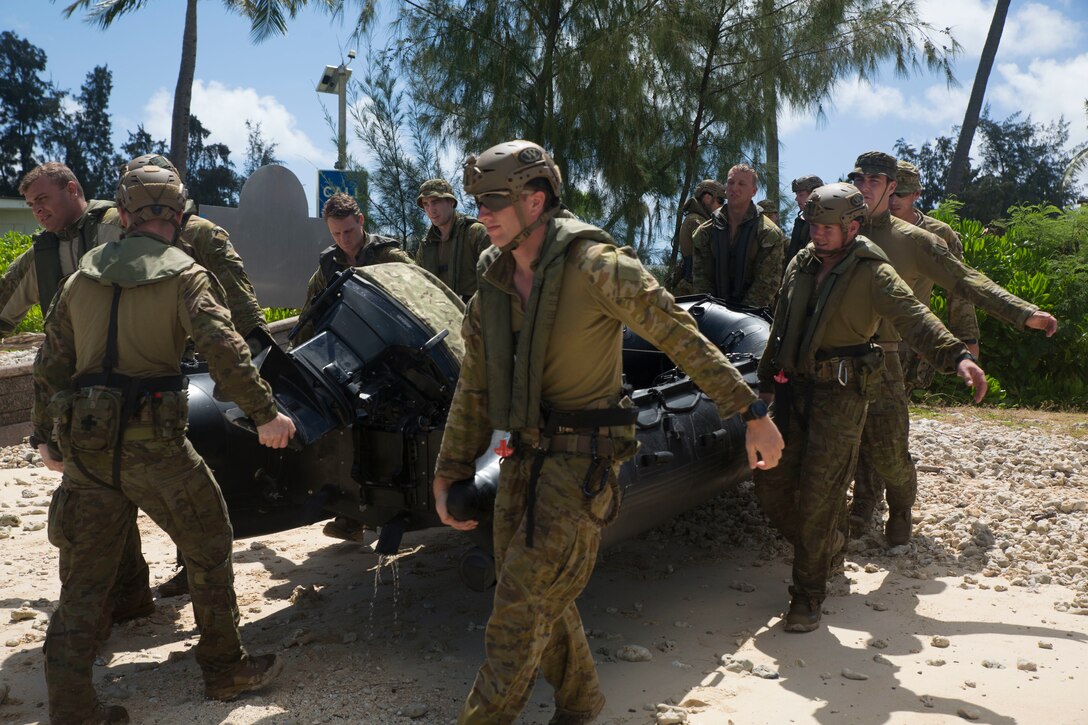 180629-M-KC456-1098 MARINE CORPS BASE HAWAII (June 29, 2018) Australian soldiers carry a combat rubber raiding craft into the water during helo-cast drills as part of Rim of the Pacific (RIMPAC) exercise on Marine Corps Base Hawaii June 29, 2018. The helo-cast training is meant to prepare the service members for an amphibious insertion during RIMPAC. RIMPAC provides high-value training for task-organized, highly-capable Marine Air-Ground Task Force and enhances the critical crisis response capability of U.S. Marines in the Pacific. Twenty-five nations, 46 ships, five submarines, about 200 aircraft and 25,000 personnel are participating in RIMPAC from June 27 to Aug. 2 in and around the Hawaiian Islands and Southern California.(U.S. Marine Corps photo by Lance Cpl. Thomas P. Miller)