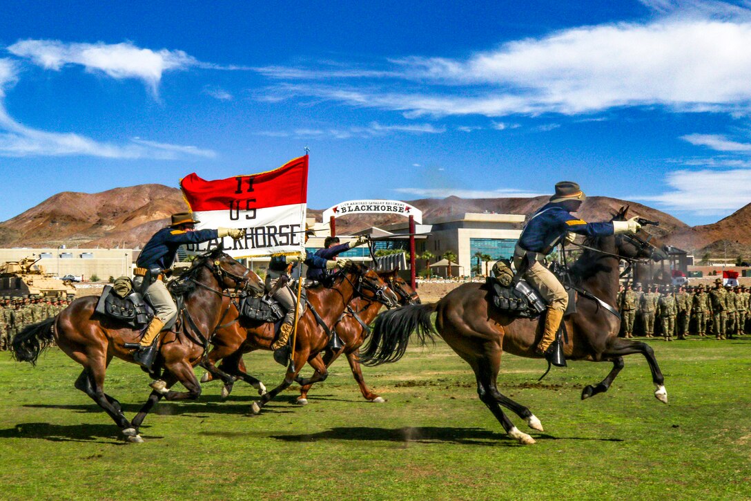 Service members ride horses during a last charge.