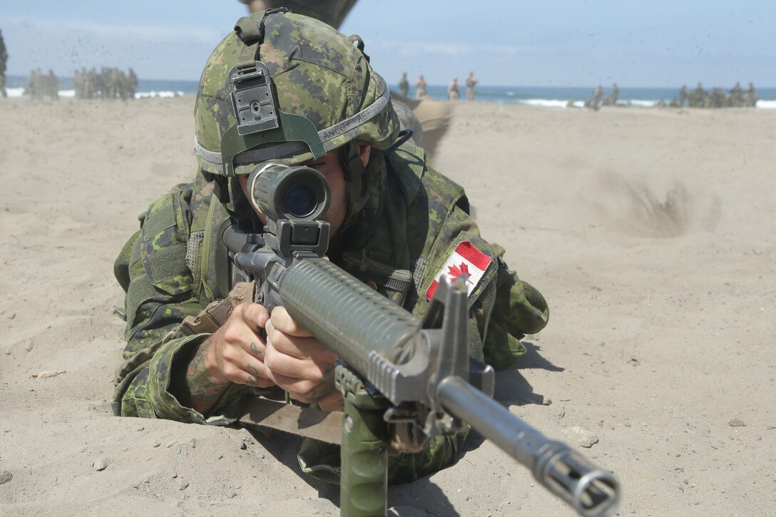 Canadian Army Pvt. François Vive va, infantryman with the Royal 22e Régiment, provides security at an assault amphibious vehicle familiarization training during Rim of the Pacific (RIMPAC) exercise at Marine Corps Base Camp Pendleton, California, June 28, 2018. RIMPAC provides a unique training opportunity, while fostering and sustaining cooperative relationships between participants critical to ensuring the safety of sea lanes and security on the world's oceans since 1971.(U.S. Marine Corps photo by Cpl. Jeremy Laboy)