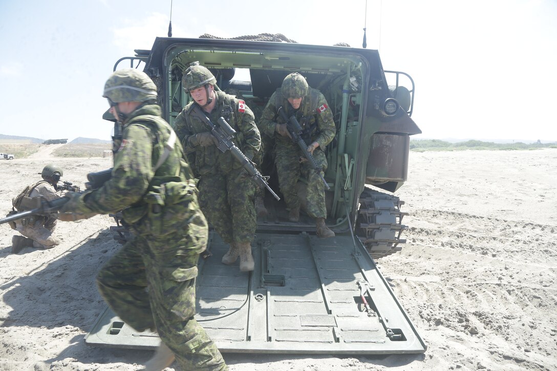 Canadian Armed Forces service members egress an AAV-P7/A1 assault amphibious vehicle during familiarization training as part of Rim of the Pacific (RIMPAC) exercise at Marine Corps Base Camp Pendleton, California, June 28, 2018. Marines training with partner nations from around the world enhances prowess. RIMPAC provides high-value training for task-organized, highly-capable Marine Air-Ground Task Force and enhances the critical crisis response capability of U.S. Marines in the Pacific. (U.S. Marine Corps photo by Cpl. Jeremy Laboy)