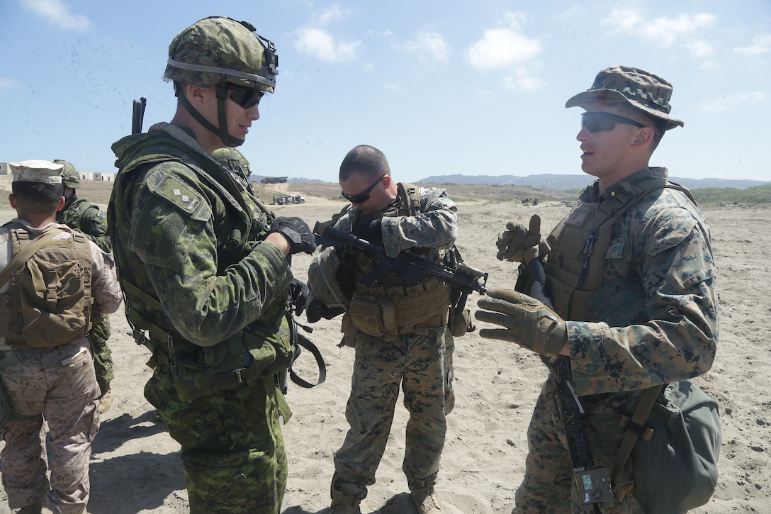 U.S. Marine Corps 2nd Lt. William Thompson, right, infantry officer with 2nd Battalion, 1st Marine Regiment, speaks to Canadian Army Lt. Jacob Simard, a member of the Royal 22e Régiment, to discuss bounding tactics during Rim of the Pacific (RIMPAC) exercise at Marine Corps Base Camp Pendleton, California, June 28, 2018. RIMPAC provides a unique training opportunity, while fostering and sustaining cooperative relationships between participants critical to ensuring the safety of sea lanes and security on the world's oceans since 1971.(U.S. Marine Corps photo by Cpl. Jeremy Laboy)