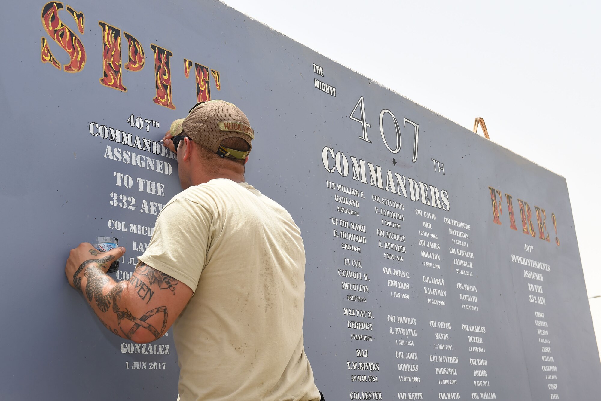 Airman paints on concrete wall