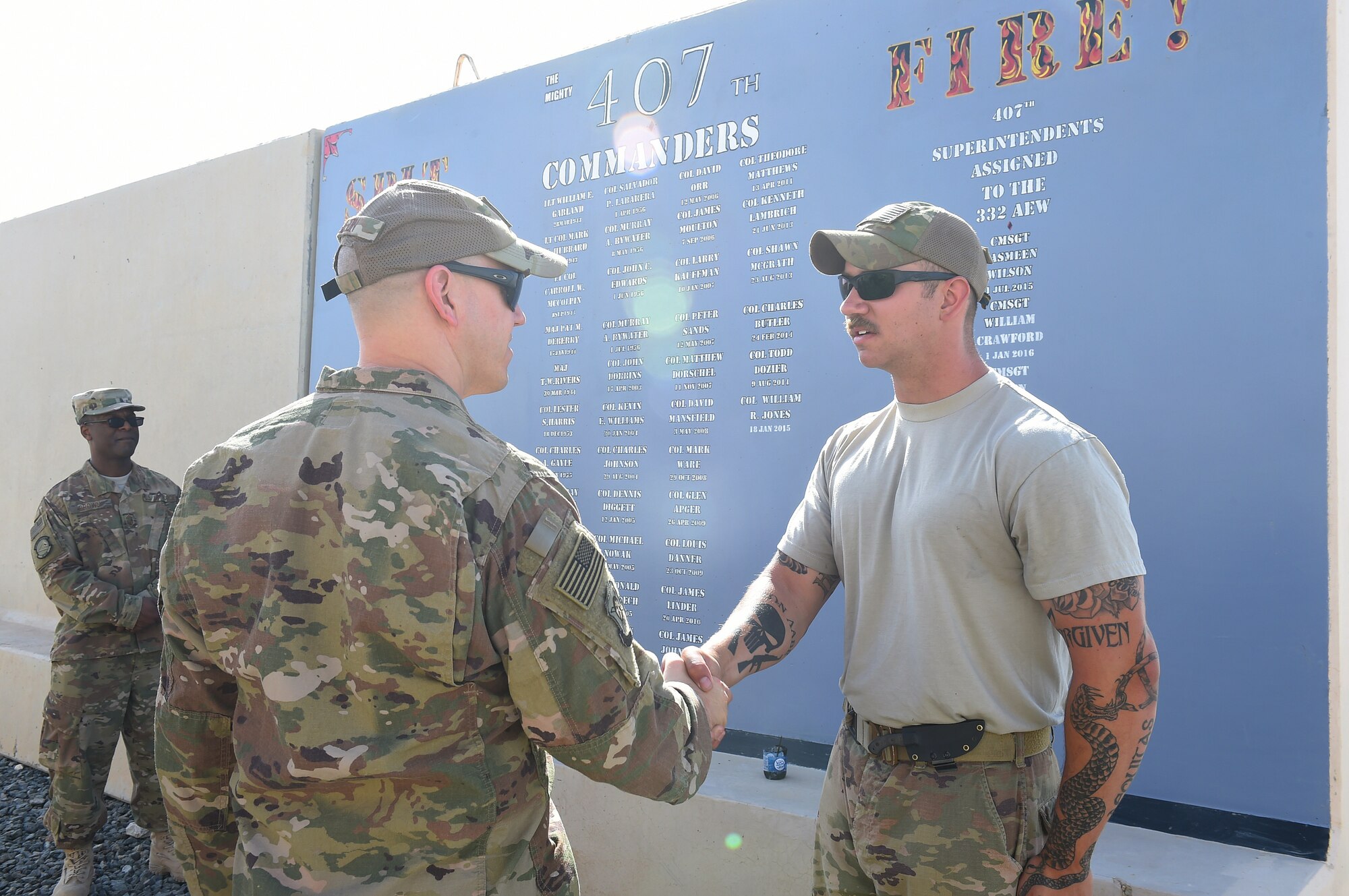 Col. shakes hands with Airman outside
