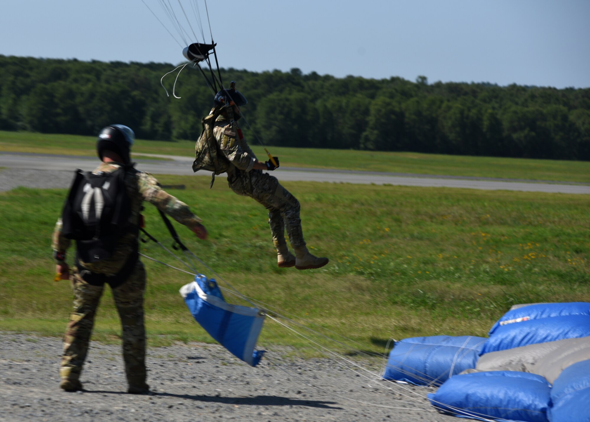 People in uniform perform and prepare for freefall jumps.