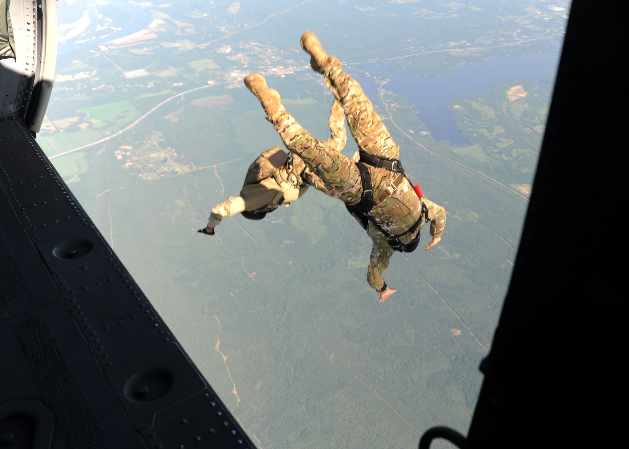 People in uniform perform and prepare for freefall jumps.