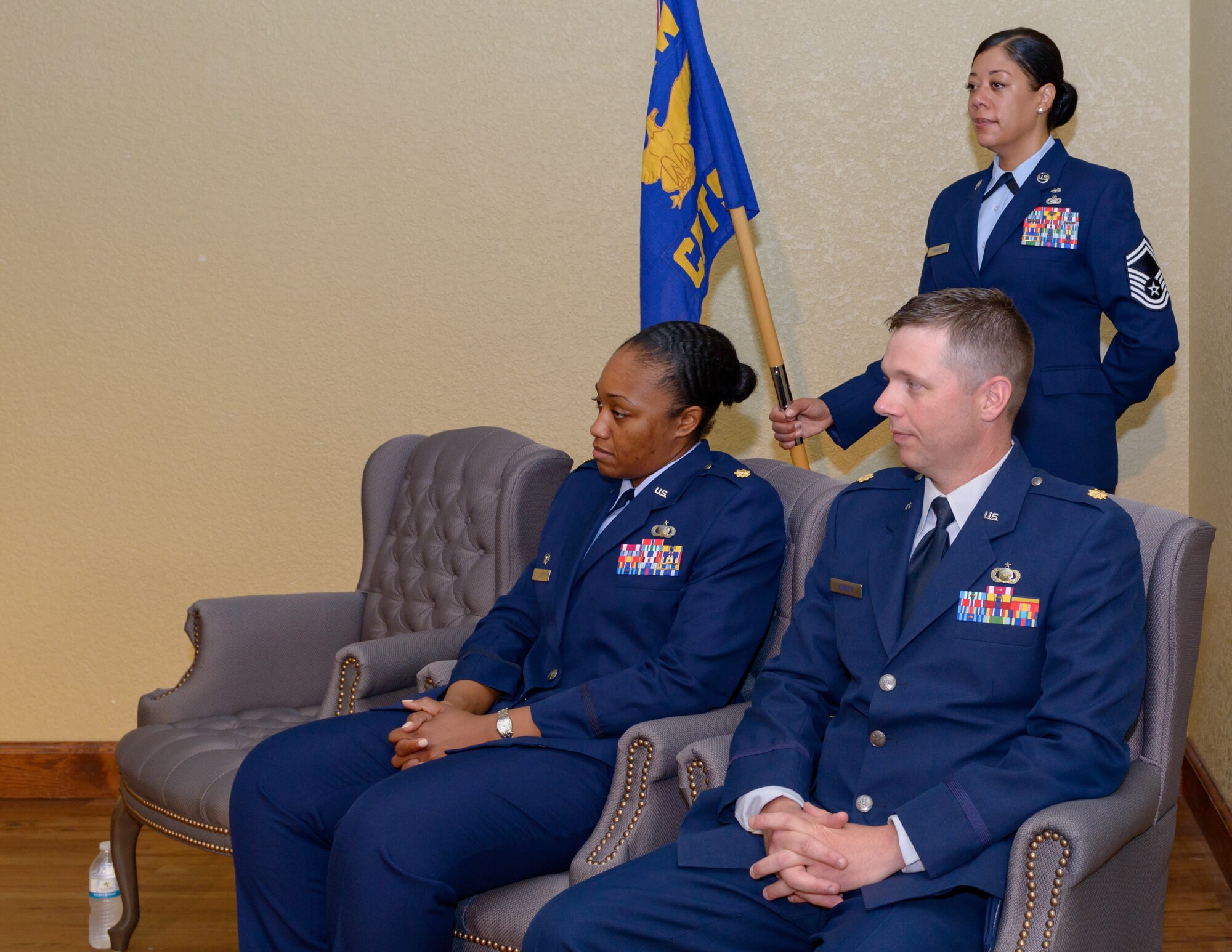 U.S. Air Force Maj. Jahayra Lowe, outgoing 81st Comptroller Squadron commander, and Maj. Daniel Lambert, incoming 81st CPTS commander, attend the 81st CPTS change of command ceremony in the Bay Breeze Event Center at Keesler Air Force Base, Mississippi, June 29, 2018. The passing of the guidon is a ceremonial symbol of exchanging command from one commander to another. (U.S. Air Force photo by Andre’ Askew)