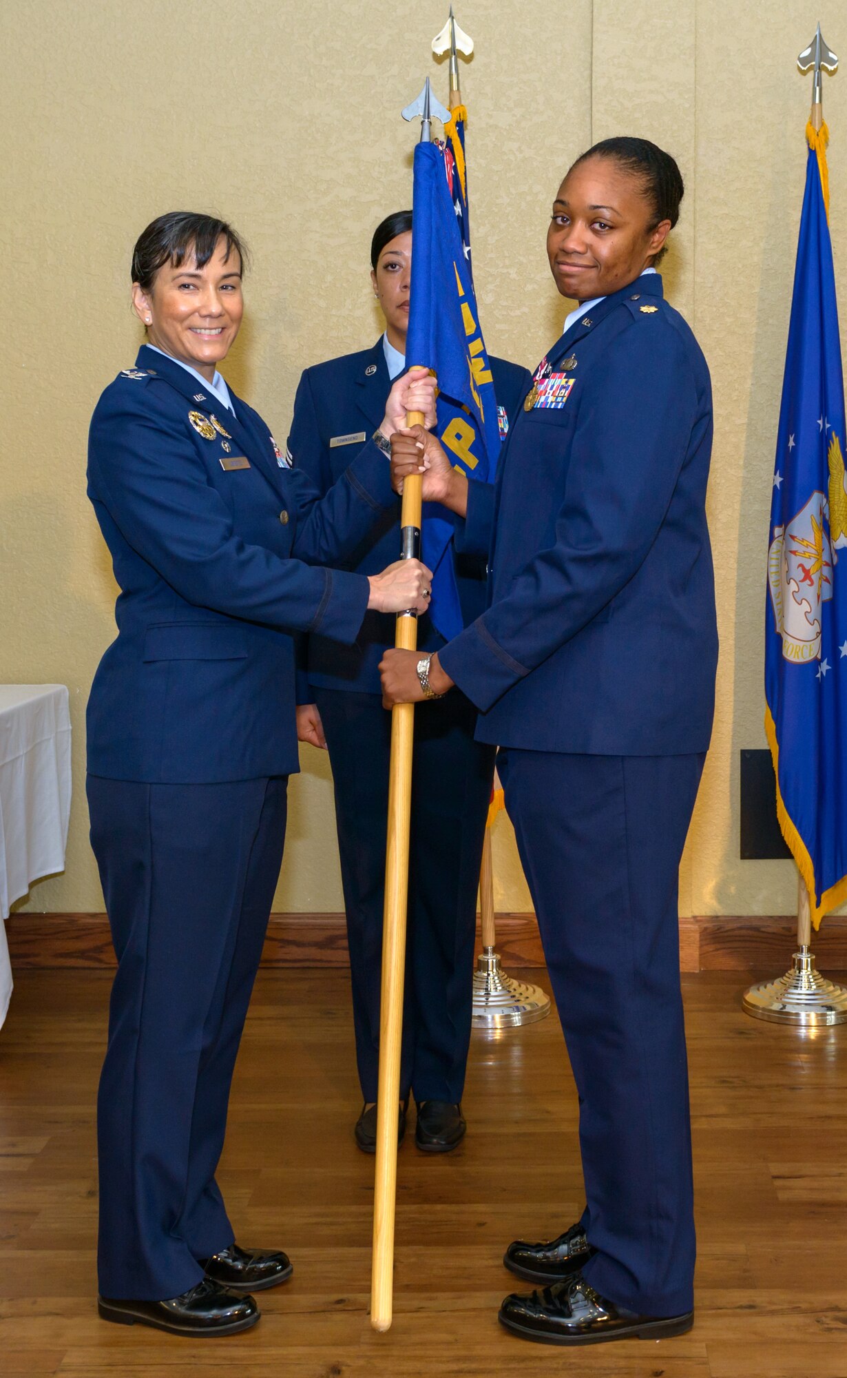 U.S. Air Force Col. Debra Lovette, 81st Training Wing commander, takes the 81st Comptroller Squadron guidon from Maj. Jahayra Lowe, outgoing 81st CPTS commander, during the 81st CPTS change of command ceremony in the Bay Breeze Event Center at Keesler Air Force Base, Mississippi, June 29, 2018. The passing of the guidon is a ceremonial symbol of exchanging command from one commander to another. (U.S. Air Force photo by Andre’ Askew)