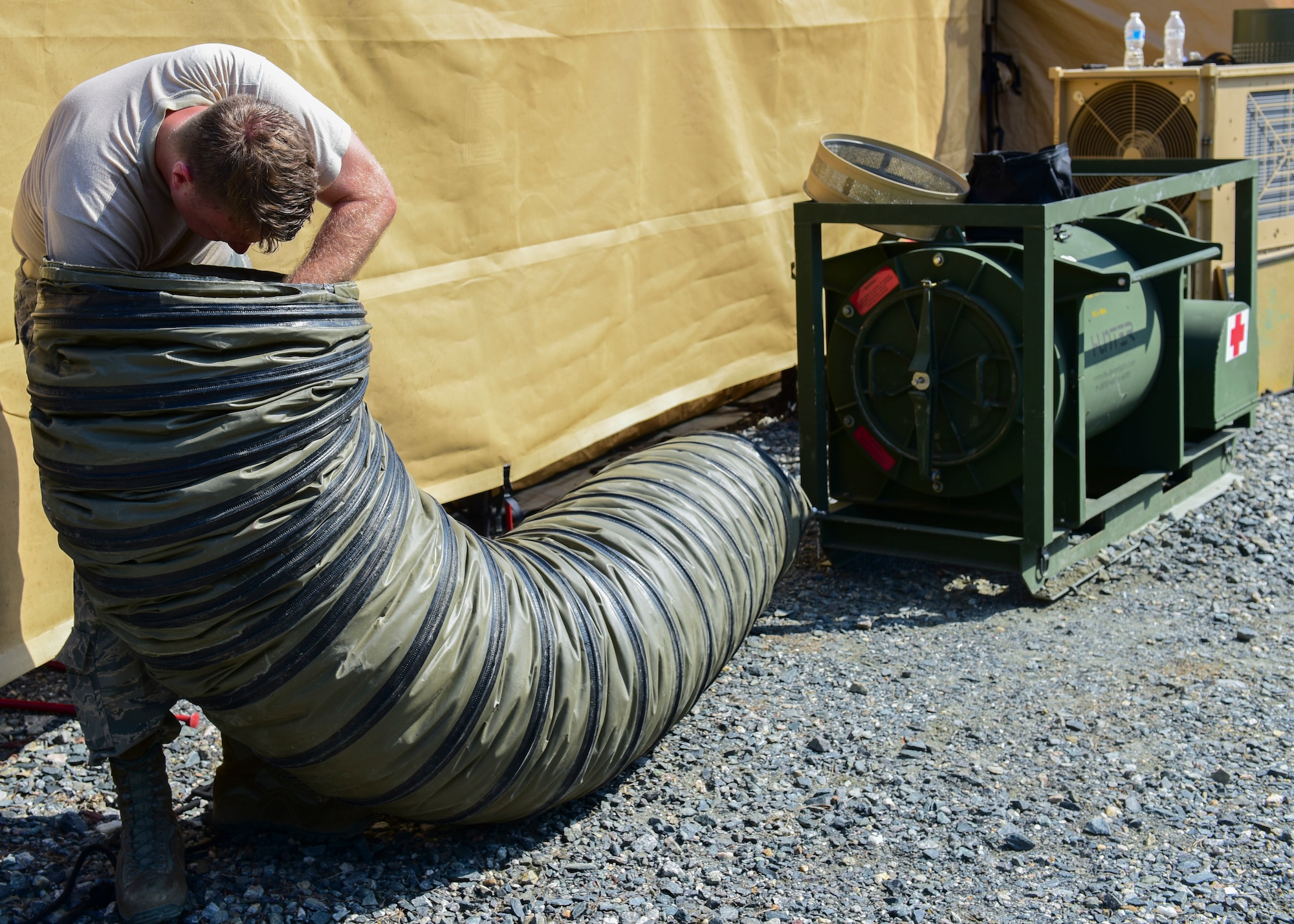 An Expeditionary Medical Systems exercise Airman assembles tent components at Joint Base Langley-Eustis, Va., June 20, 2018. A core group of Airmen were trained on tent assembly prior to the exercise and were then tasked with teaching exercise volunteers on the newly learned procedures. (U.S. Air Force photo by Airman 1st Class Monica Roybal)
