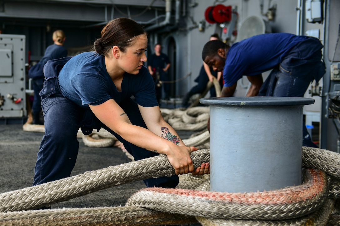 Seaman handles mooring line on fantail of aircraft carrier USS Theodore Roosevelt during regularly scheduled port visit to Singapore, April 2, 2018 (U.S. Navy/Michael Colemanberry)