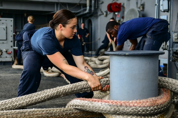 Seaman handles mooring line on fantail of aircraft carrier USS Theodore Roosevelt during regularly scheduled port visit to Singapore, April 2, 2018 (U.S. Navy/Michael Colemanberry)