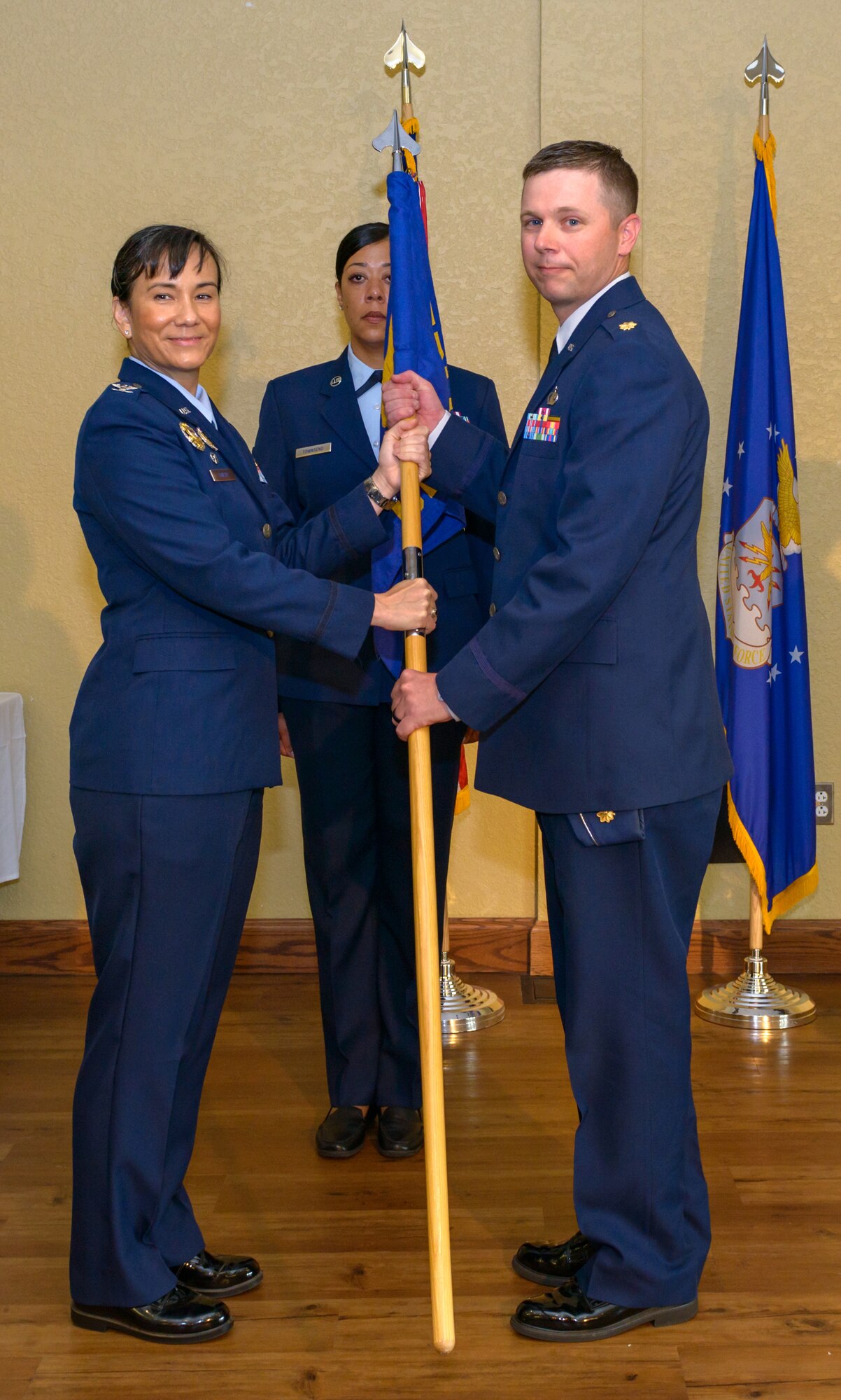 U.S. Air Force Col. Debra Lovette, 81st Training Wing commander, passes the 81st Comptroller Squadron guidon to Maj. Daniel Lambert, 81st CPTS commander, during the 81st CPTS change of command ceremony in the Bay Breeze Event Center at Keesler Air Force Base, Mississippi, June 29, 2018. The passing of the guidon is a ceremonial symbol of exchanging command from one commander to another. (U.S. Air Force photo by Andre’ Askew)