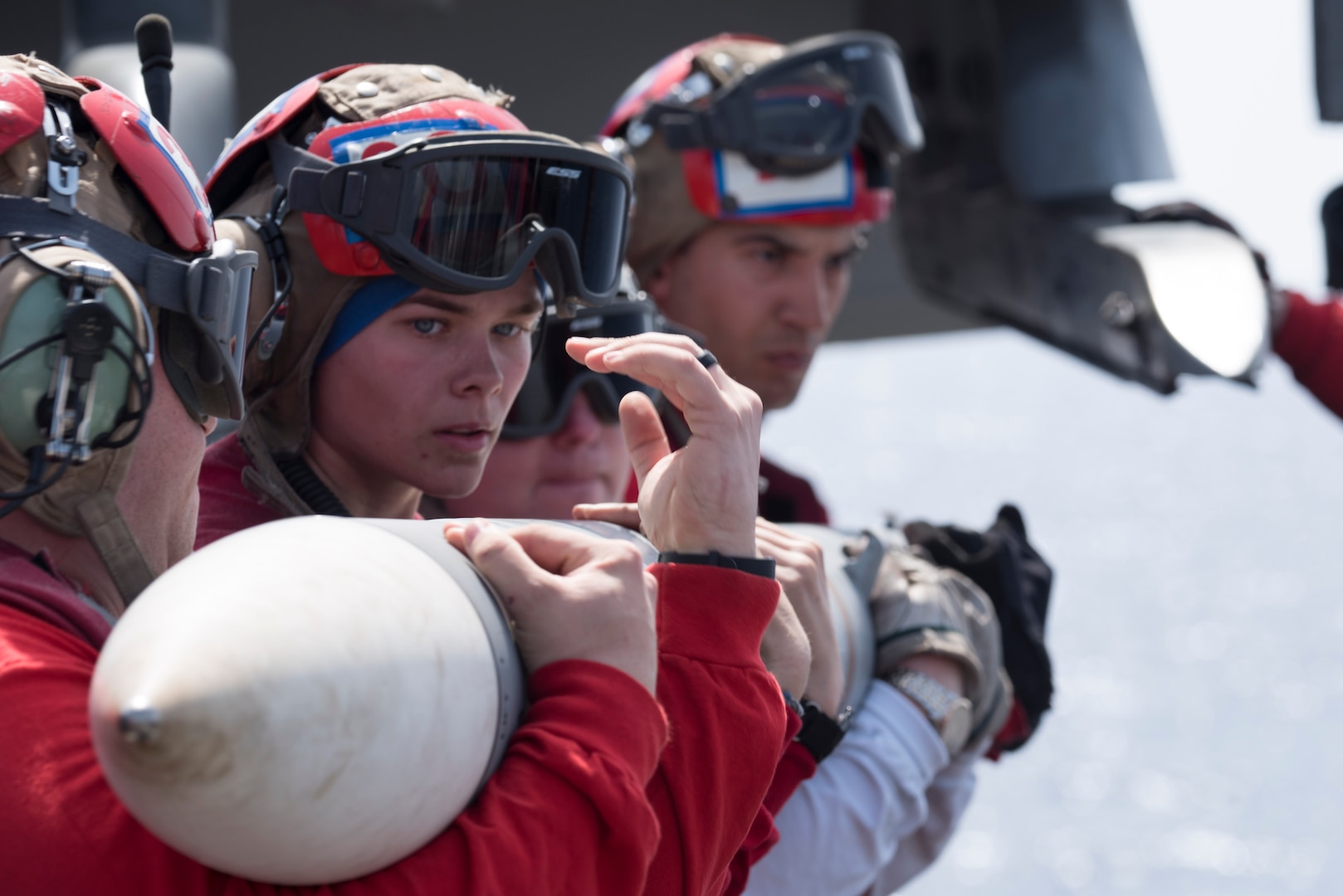 Aviation Ordnanceman works with shipmates to upload ordnance to F/A-18 Super Hornet on flight deck aboard USS Harry S. Truman, Mediterranean Sea, May 3, 2018 (U.S. Navy/Thomas Gooley)