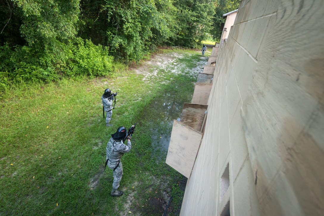 Airmen from the 23d Security Forces Squadron (SFS) take aim at an opposing assailant during a Force on Force training scenario, June 29, 2018, at Moody Air Force Base, Ga. This training was held to ensure SFS Airmen are proficient in various tactics and procedures such as: building clear out, team movements, hostage rescue and properly applying cover fire. The scenario required Airmen to maneuver through multiple buildings to rescue a simulated victim guarded by opposing forces. (U.S. Air Force photo Airman 1st Class Eugene Oliver)