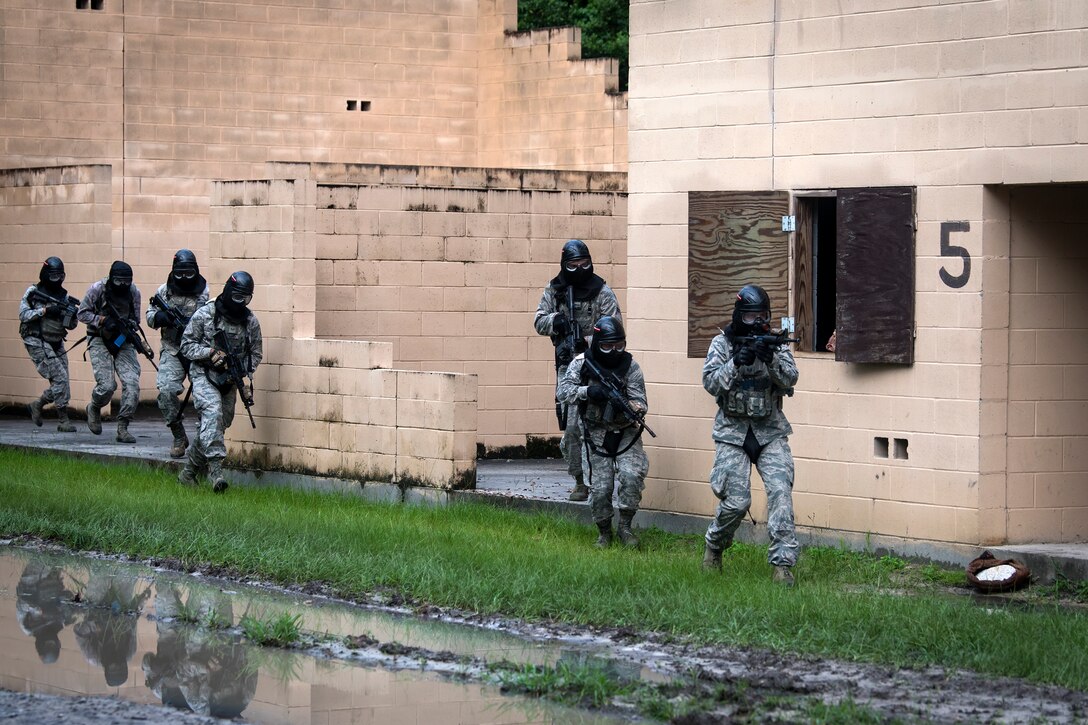 Airmen from the 23d Security Forces Squadron (SFS) run to the next building while providing cover fire during a Force on Force training scenario, June 29, 2018, at Moody Air Force Base, Ga. This training was held to ensure SFS Airmen are proficient in various tactics and procedures such as: building clear out, team movements, hostage rescue and properly applying cover fire. The scenario required Airmen to maneuver through multiple buildings to rescue a simulated victim guarded by opposing forces. (U.S. Air Force photo Airman 1st Class Eugene Oliver)