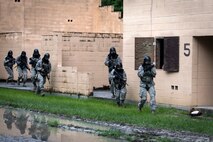 Airmen from the 23d Security Forces Squadron (SFS) run to the next building while providing cover fire during a Force on Force training scenario, June 29, 2018, at Moody Air Force Base, Ga. This training was held to ensure SFS Airmen are proficient in various tactics and procedures such as: building clear out, team movements, hostage rescue and properly applying cover fire. The scenario required Airmen to maneuver through multiple buildings to rescue a simulated victim guarded by opposing forces. (U.S. Air Force photo Airman 1st Class Eugene Oliver)