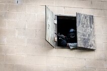 An Airman from the 23d Security Forces Squadron (SFS) defends his position during a Force on Force training scenario, June 29, 2018, at Moody Air Force Base, Ga. This training was held to ensure SFS Airmen are proficient in various tactics and procedures such as: building clear out, team movements, hostage rescue and properly applying cover fire. The scenario required Airmen to maneuver through multiple buildings to rescue a simulated victim guarded by opposing forces. (U.S. Air Force photo Airman 1st Class Eugene Oliver)