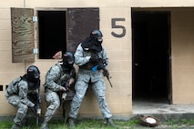 Airmen from the 23d Security Forces Squadron (SFS) prepare to clear a building during a Force on Force training scenario, June 29, 2018, at Moody Air Force Base, Ga. This training was held to ensure SFS Airmen are proficient in various tactics and procedures such as: building clear out, team movements, hostage rescue and properly applying cover fire. The scenario required Airmen to maneuver through multiple buildings to rescue a simulated victim guarded by opposing forces. (U.S. Air Force photo Airman 1st Class Eugene Oliver)
