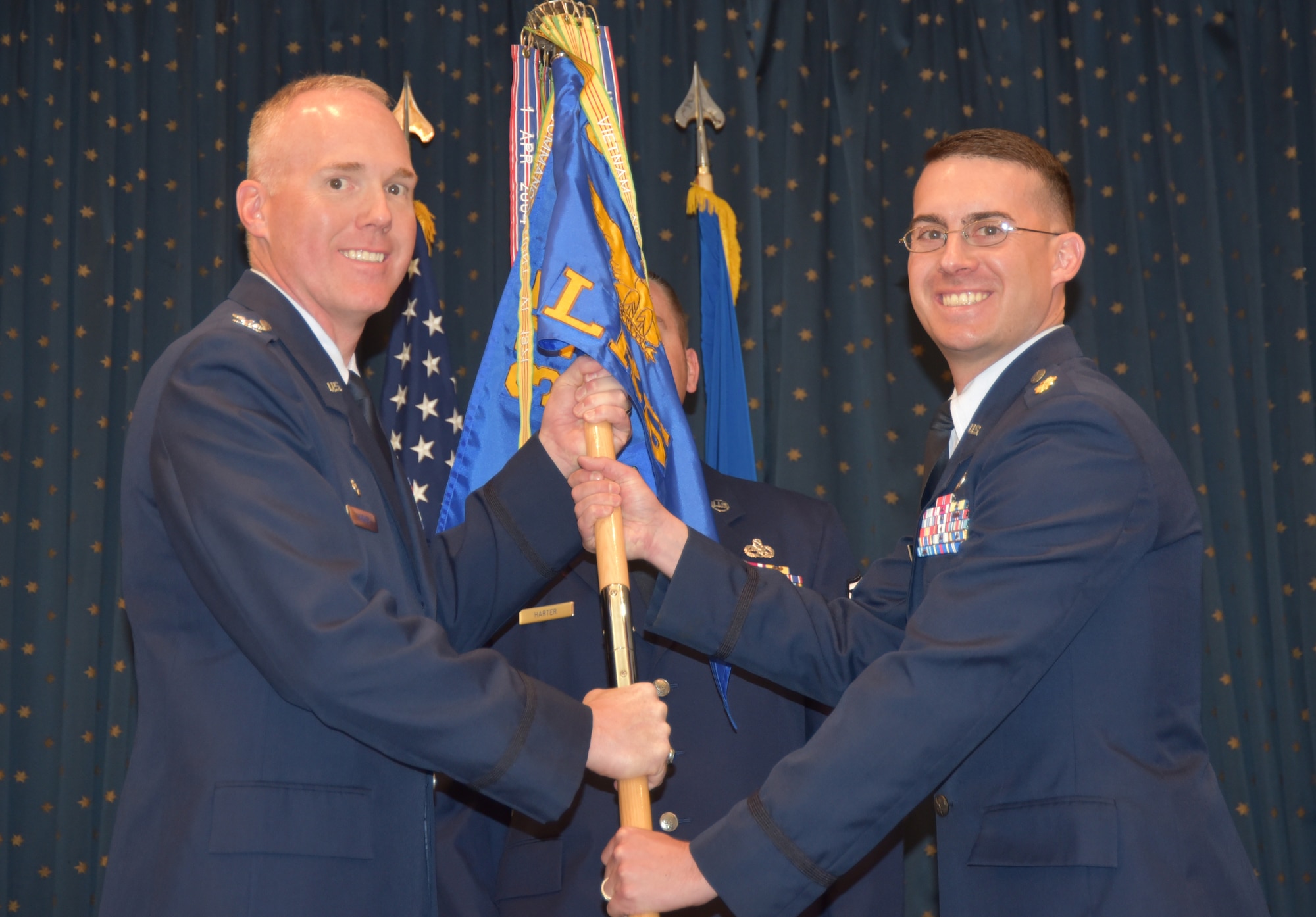 Maj. Daniel McGuire (right) takes the 377th Logistics Readiness Squadron guidon from 377th MSG commander Col. Michael Harner at a ceremony June 27. McGuire is one of three new squadron commanders to take command in June.  (U.S. Air Force photo by Kirtland Public Affairs)