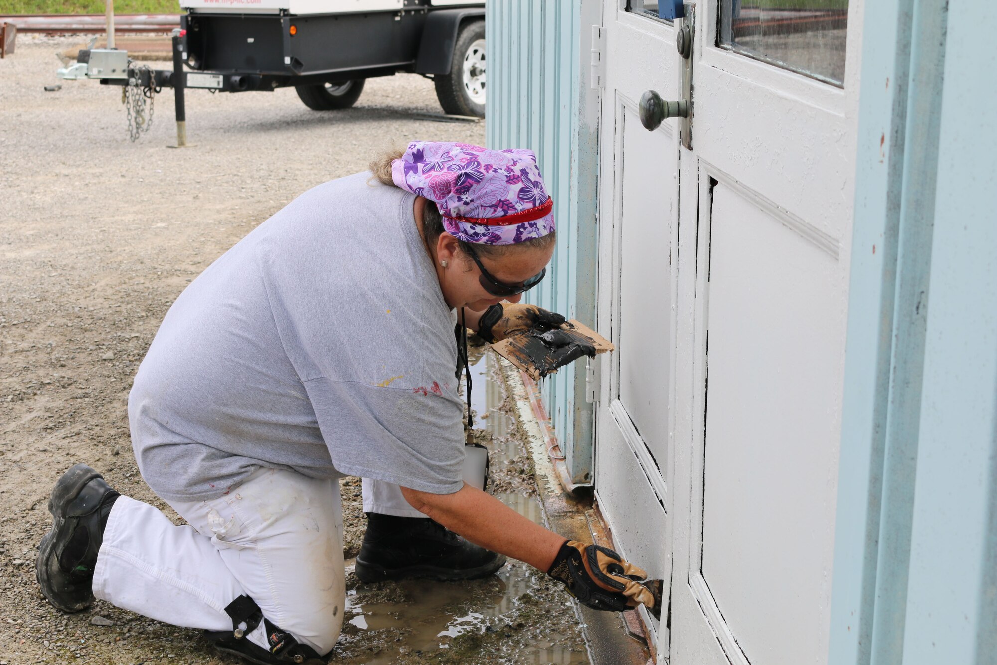 Paint Shop team member Jill Clark uses epoxy to patch a door at Arnold Air Force Base. (U.S. Air Force photo/Bradley Hicks) (This image was manipulated by obscuring badges for security purposes)