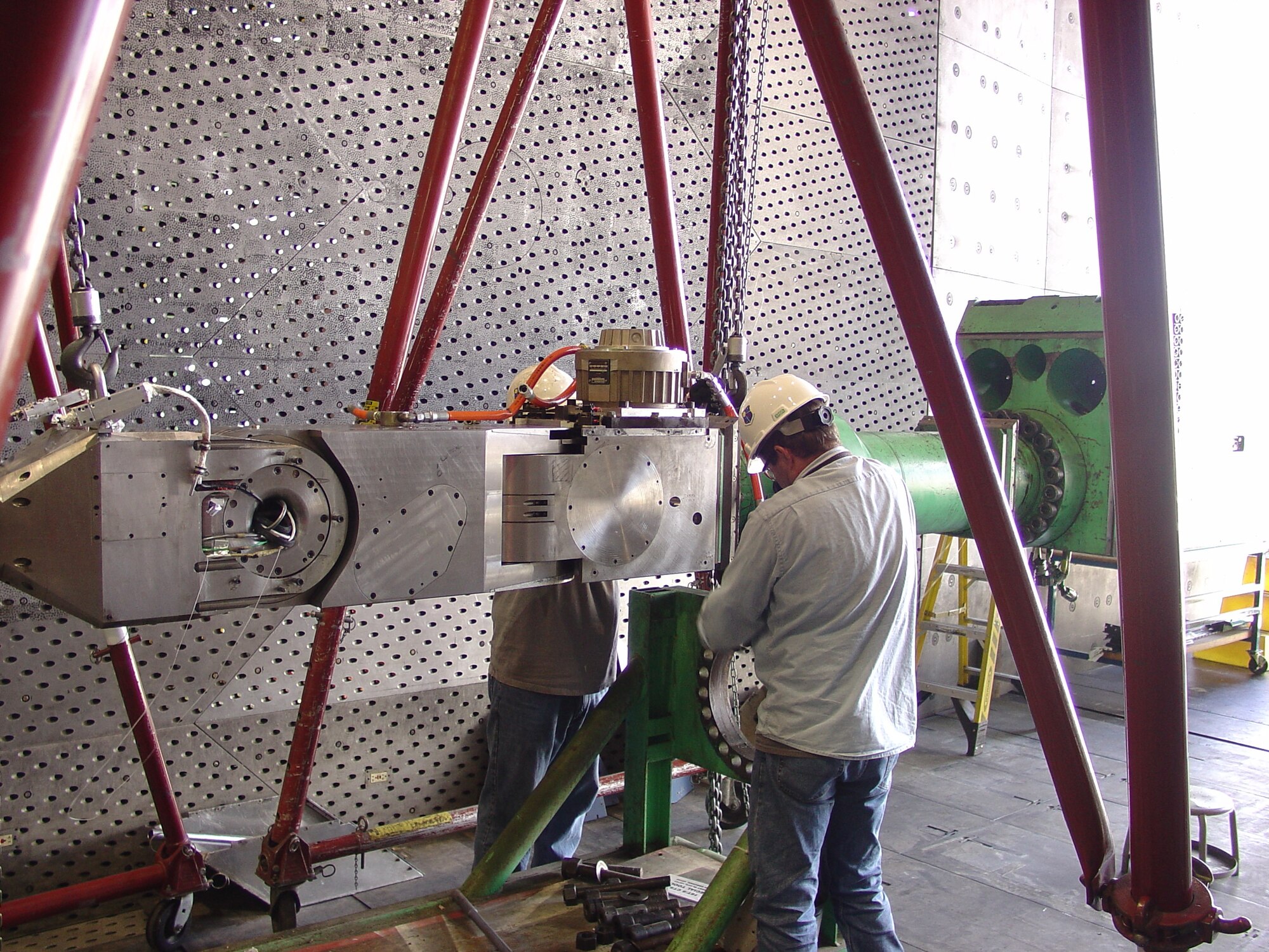 Machinists Jeff Farris, right, and Jim Lynch install the 16T Captive Trajectory System Angular Drive Mechanism onto the CTS Axial boom. Systems and software in Propulsion Wind Tunnel 16T at Arnold Air Force Base were upgraded this fiscal year as part of a multimillion dollar effort. (U.S. Air Force Photo)