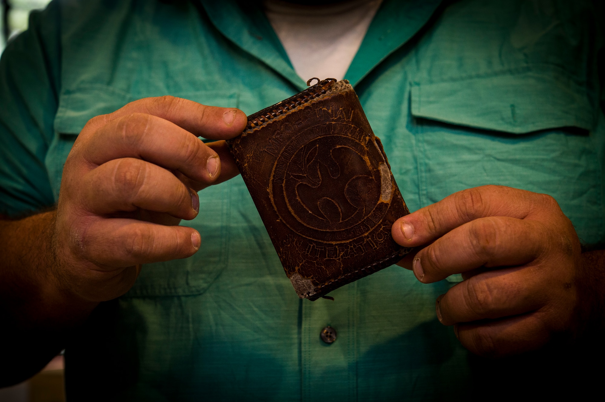 Former Army Sgt. Tony Fantasia displays the wallet that he attributes saving his life at his shop in San Antonio, Texas, June 29th, 2018. Working with leather has aided Fantasia’s battle with PTSD that he developed after his deployments to Southwest Asia as a medic. He now runs an outreach program for veterans focusing on various artistic outlets. (U.S. Air Force photo by Senior Airman Keifer Bowes)