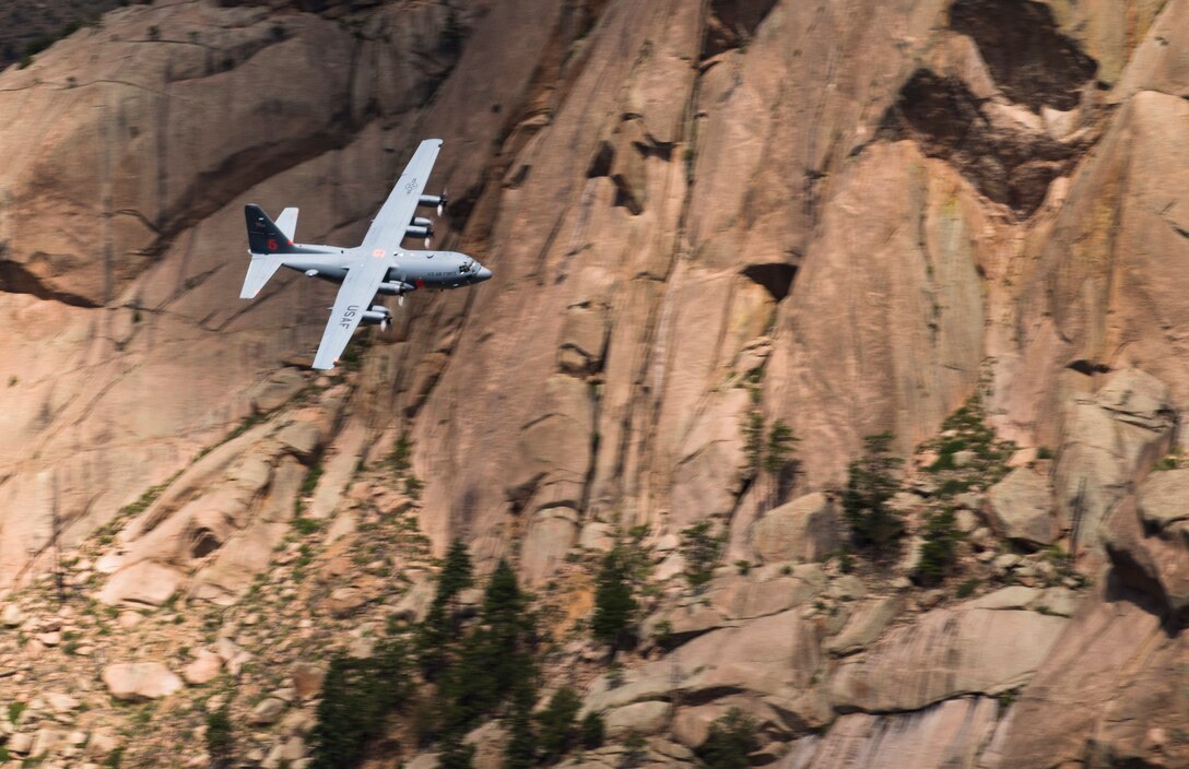 A 302nd Airlift Wing C-130 Hercules aircraft flies through a mountain pass in central Colorado, June 23, 2018.