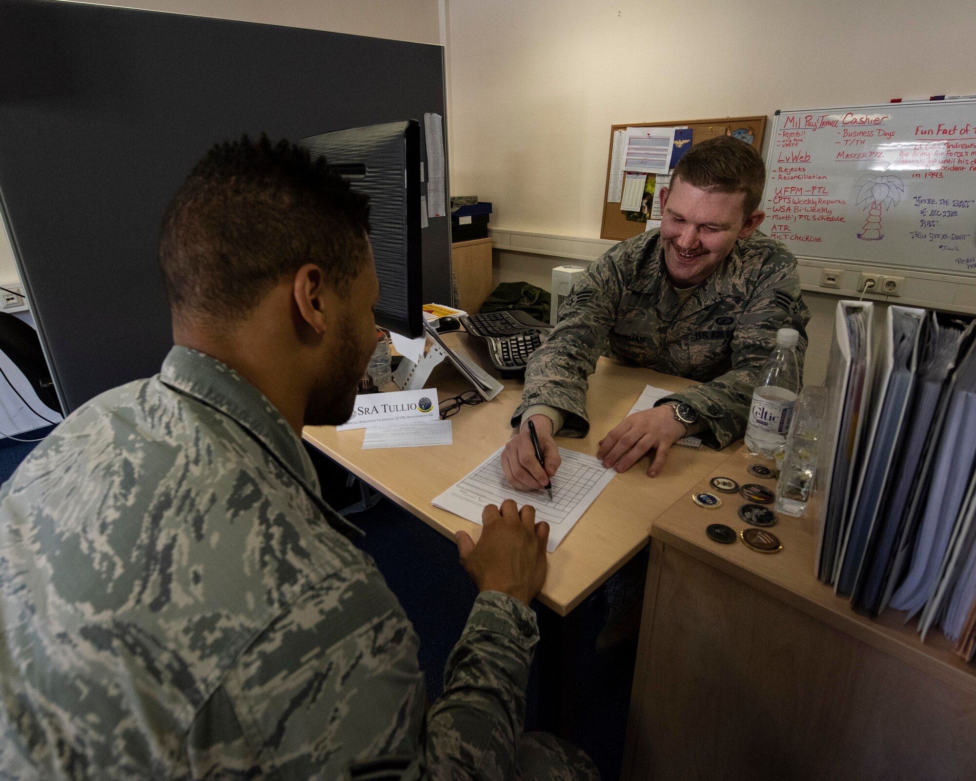 Senior Airman Cody Chrisman, a military pay technician with the 194th Wing, assists Senior Airman Craig Harris, 52nd Comptroller Flight financial management technician, with financial checklist during training April 17, 2018 at Spangdahlem Air Base, Germany. Guardsmen from the 141st ARW and 194th Wing travelled to Spangdahlem to achieve training requirements, gain helpful tricks of the trade, as well as assist in task completion where possible.