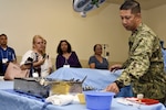 Lt. Cmdr. Kirby Jahnke, Navy Medicine Training Support Center, shows medical instruments to a tour group of San Antonio middle and high school guidance counselors June 27. The tour provided educators and counselors with a general overview of the Navy, to raise awareness of Navy career opportunities through a tour of the medical training campus.