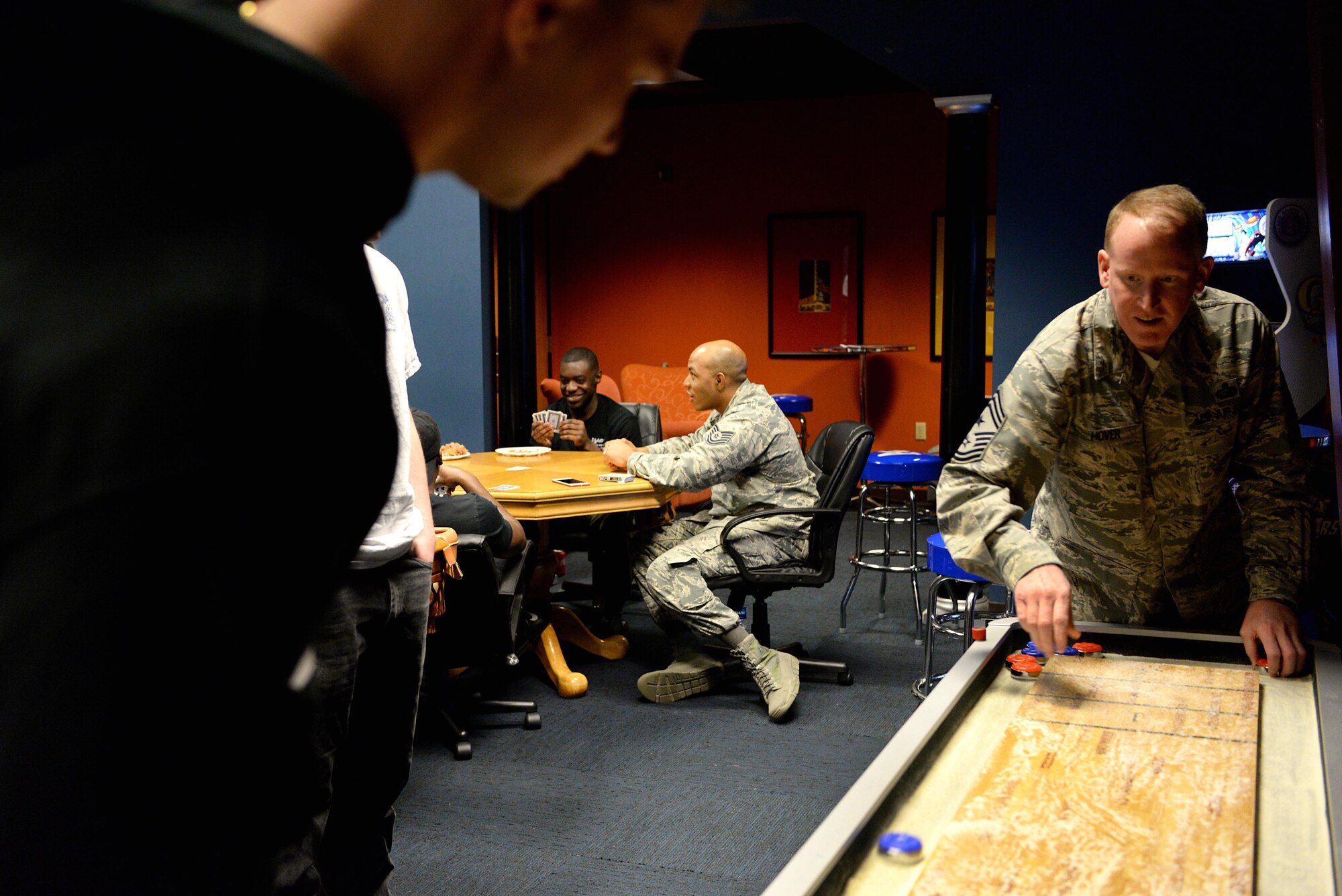 Chief Master Sgt. Johnathan Hover, 14th Flying Training Wing command chief, spreads sand across the shuffleboard table March 2, 2018. Dorm dinners allow senior leaders to show the junior enlisted members they can provide a positive service to others no matter the rank on their uniforms. (U.S. Air Force photo by Airman 1st Class Keith Holcomb)