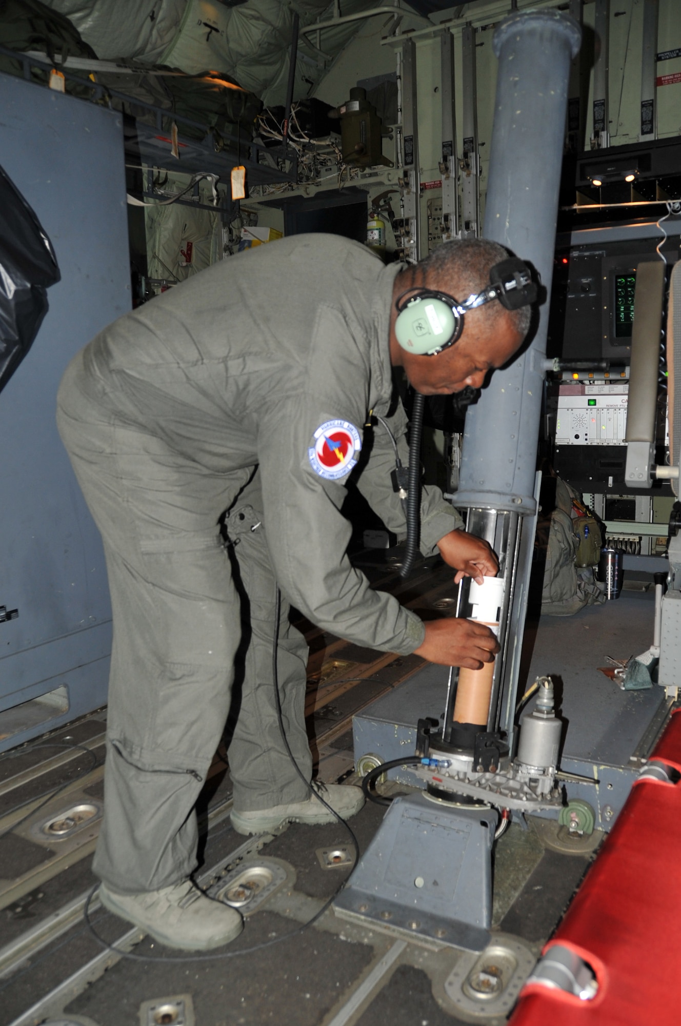 Master Sgt. Troy Bickham, 53rd Weather Reconnaissance Squadron loadmaster, loads a dropsonde during a routine training flight for calibration testing. (U.S. Air Force photo by Master Sgt. Jessica Kendziorek)