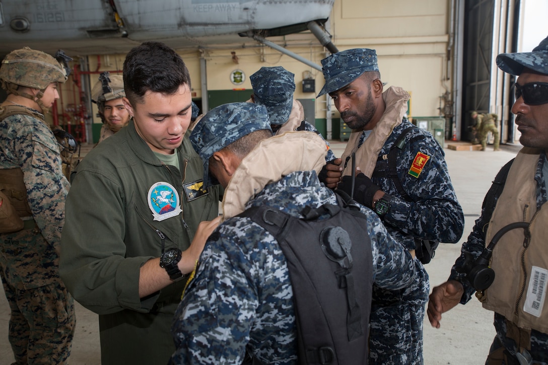 U.S. Marine Cpl. Domaneck Franco, a crew chief with Marine Heavy Helicopter Squadron 463, Marine Aircraft Group 24, 1st Marine Aircraft Wing, examines a Sri Lankan Marine’s gear during ground-air integration training (GAIT) as part of Rim of the Pacific (RIMPAC) exercise at Marine Corps Air Station Kaneohe Bay, Hawaii, June 27, 2018. GAIT provides the service members with familiarity with boarding and exiting an aircraft. RIMPAC provides high-value training for task-organized, highly-capable Marine Air-Ground Task Force and enhances the critical crisis response capability of U.S. Marines in the Pacific. Twenty-five nations, 46 ships, five submarines, about 200 aircraft and 25,000 personnel are participating in RIMPAC from June 27 to Aug. 2 in and around the Hawaiian Islands and Southern California.