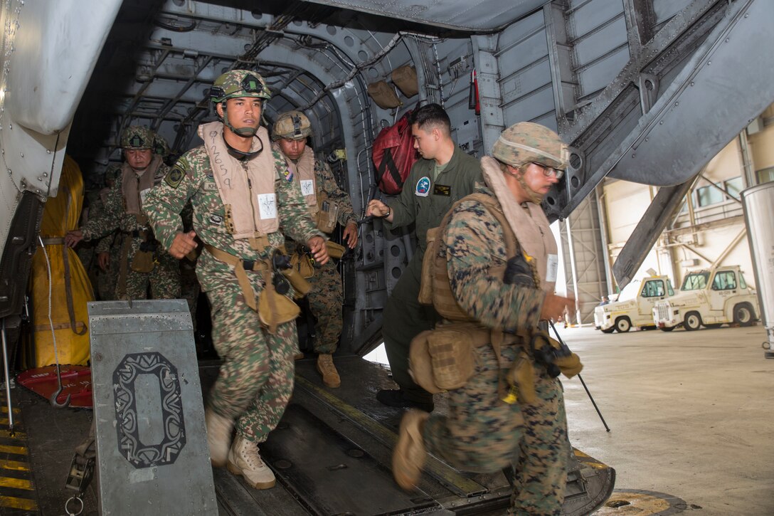 Malaysian service members and U.S. Marines disembark a CH-53E Super Stallion helicopter during ground-air integration training (GAIT) as part of Rim of the Pacific (RIMPAC) exercise at Marine Corps Air Station Kaneohe Bay, Hawaii, June 27, 2018. GAIT provides the service members with familiarity with boarding and exiting an aircraft. RIMPAC provides high-value training for task-organized, highly-capable Marine Air-Ground Task Force and enhances the critical crisis response capability of U.S. Marines in the Pacific. Twenty-five nations, 46 ships, five submarines, about 200 aircraft and 25,000 personnel are participating in RIMPAC from June 27 to Aug. 2 in and around the Hawaiian Islands and Southern California.
