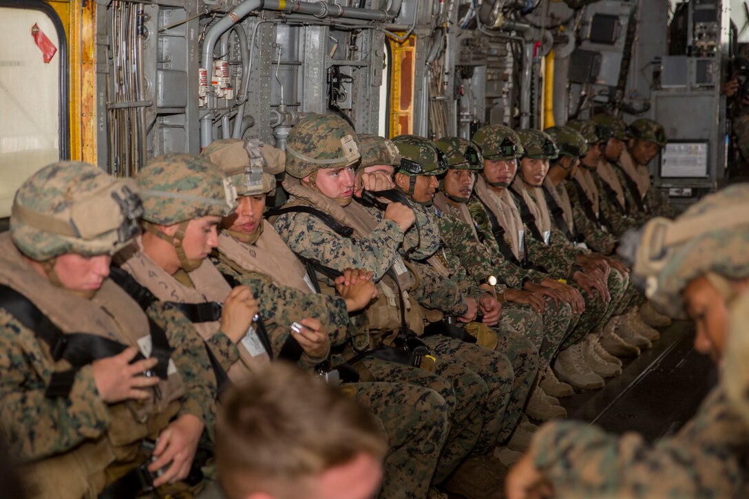 Malaysian service members and U.S. Marines prepare to disembark from an CH-53E Super Stallion helicopter during ground-air integration training (GAIT) as part of Rim of the Pacific (RIMPAC) exercise at Marine Corps Air Station Kaneohe Bay, Hawaii, June 27, 2018. GAIT provides the service members with familiarity with boarding and exiting an aircraft. RIMPAC provides high-value training for task-organized, highly-capable Marine Air-Ground Task Force and enhances the critical crisis response capability of U.S. Marines in the Pacific. Twenty-five nations, 46 ships, five submarines, about 200 aircraft and 25,000 personnel are participating in RIMPAC from June 27 to Aug. 2 in and around the Hawaiian Islands and Southern California.
