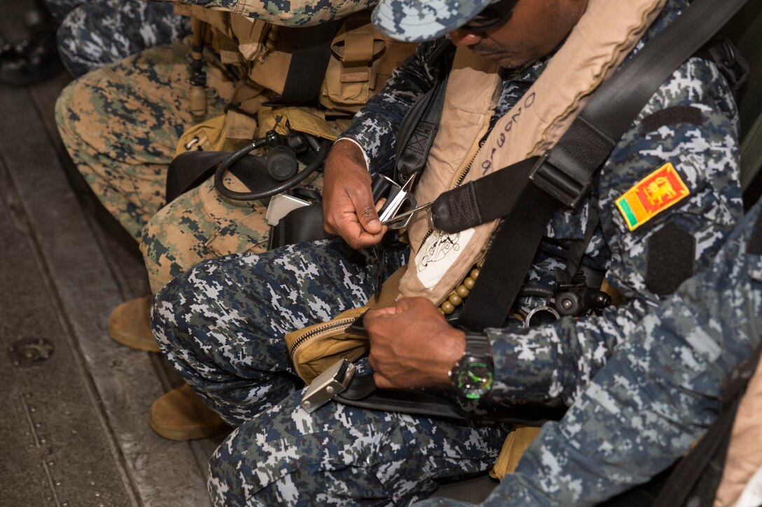 Sri Lankan and U.S. Marines fasten their seat beats aboard a CH-53E Super Stallion helicopter during ground-air integration training (GAIT) as part of Rim of the Pacific (RIMPAC) exercise at Marine Corps Air Station Kaneohe Bay, Hawaii, June 27, 2018. GAIT provides the service members with familiarity with boarding and exiting an aircraft. RIMPAC provides high-value training for task-organized, highly-capable Marine Air-Ground Task Force and enhances the critical crisis response capability of U.S. Marines in the Pacific. Twenty-five nations, 46 ships, five submarines, about 200 aircraft and 25,000 personnel are participating in RIMPAC from June 27 to Aug. 2 in and around the Hawaiian Islands and Southern California.