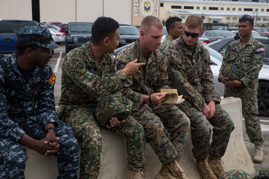 U.S., Malaysian, and Sri Lankan service members discuss training and tactics during ground-air integration training (GAIT) as part of Rim of the Pacific (RIMPAC) exercise at Marine Corps Air Station Kaneohe Bay, Hawaii, June 27, 2018. GAIT provides the service members with familiarity with boarding and exiting an aircraft. RIMPAC provides high-value training for task-organized, highly-capable Marine Air-Ground Task Force and enhances the critical crisis response capability of U.S. Marines in the Pacific. Twenty-five nations, 46 ships, five submarines, about 200 aircraft and 25,000 personnel are participating in RIMPAC from June 27 to Aug. 2 in and around the Hawaiian Islands and Southern California.