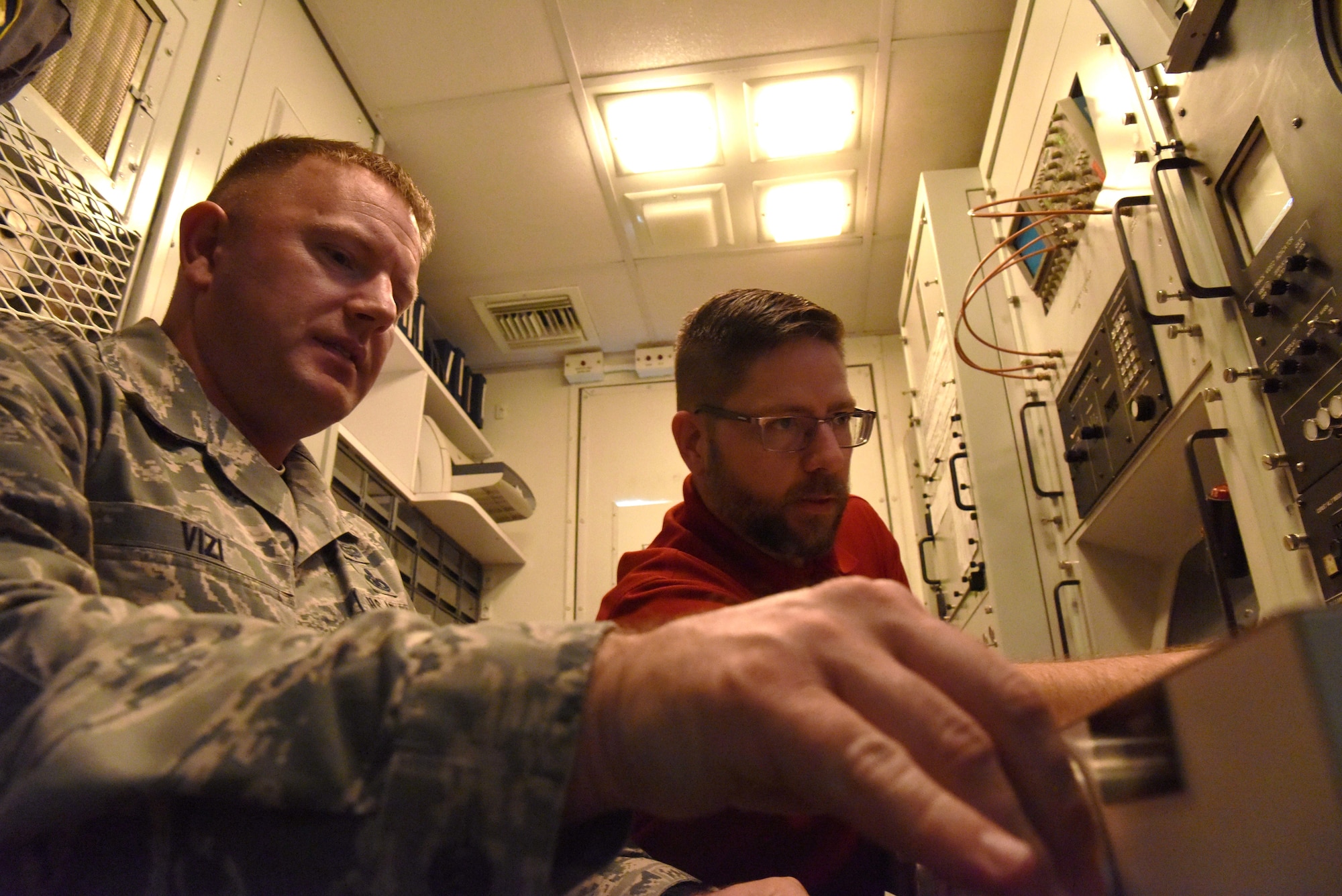 Shawn Pyle, 28th Operations Support Squadron range manager, shows Chief Master Sgt. Adam Vizi, the 28th Bomb Wing command chief, how to use a radar on a computer screen to Col. John Edwards, 28th Bomb Wing commander, at the Powder River Training Complex in Colony, Wyoming, June 21, 2018. The PRTC is a 34,000-square mile training facility where aircraft from across the Air Force can practice how to combat threats with new technology. (U.S. Air Force phot by Airman 1st Class Thomas Karol)