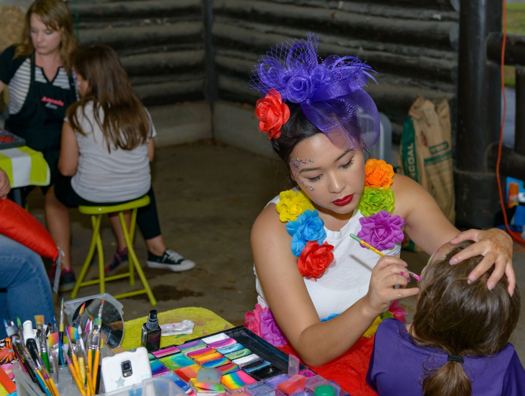 Catherine Ha, Copycats Face Painting owner, applies face paint to Keesler families during Freedom Fest at Marina Park on Keesler Air Force Base, Mississippi, June 30, 2018. The event included carnival rides, a burger cook-off, hot wings and watermelon eating competitions and a fireworks display. (U.S. Air Force photo by Andre’ Askew)