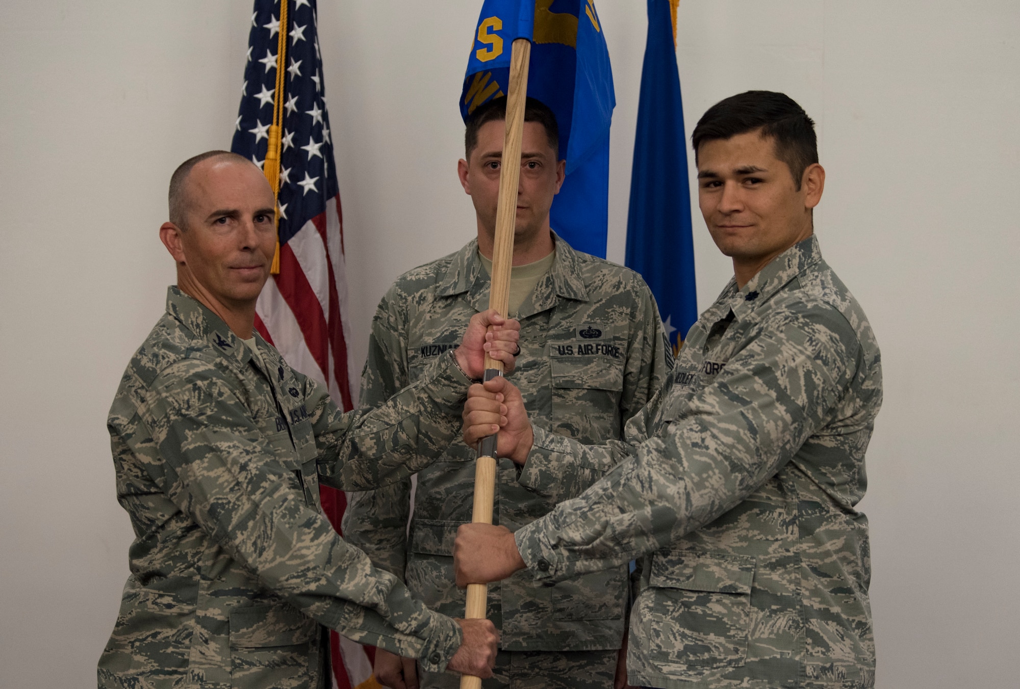Col. Steven Behmer, U. S. Air Force Weapons School commandant, passes a guidon to Lt. Col. Douglas Medley, 32nd Weapons Squadron commander during an assumption of command ceremony at Nellis Air Force Base, Nevada, June 28, 2018. The 32nd WPS will focus on the Cyber Warfare Operations Weapons Instructor Course taught at the Weapons School. (U.S. Air Force photo by Airman 1st Class Andrew D. Sarver)