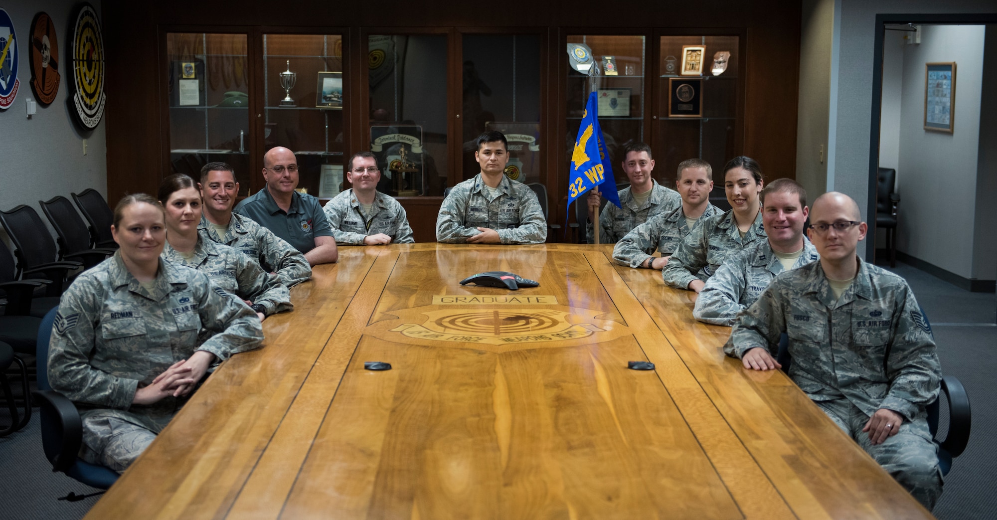 Members assigned to the 32nd Weapons Squadron gather around a table after an assumption of command ceremony at Nellis Air Force Base, Nevada, June 28, 2018. The 32nd WPS is the newest squadron in the U.S. Air Force Weapons School. (U.S. Air Force photo by Airman 1st Class Andrew D. Sarver)