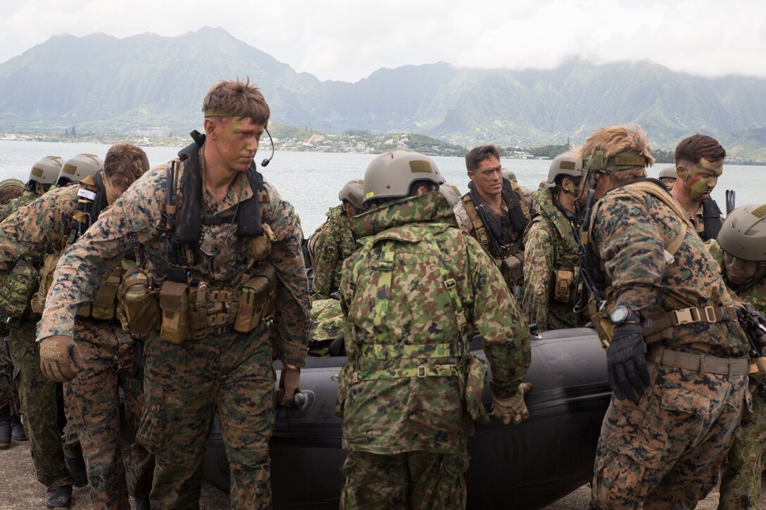 U.S. Marines with the 3rd Reconnaissance Battalion and Japanese soldiers with 2nd Regiment, Amphibious Rapid Deployment Brigade, carry a combat rubber raiding craft ashore after during amphibious operations as part of Rim of the Pacific (RIMPAC) exercise on Marine Corps Base Hawaii July 2, 2018. Twenty-Five nations, more than 45 ships and submarines, about 200 aircraft, and 25,000 personnel are participating in RIMPAC from June 27 to Aug. 2 in and around the Hawaiian Islands and Southern California. The world's largest international maritime exercise, RIMPAC provides a unique training opportunity while fostering and sustaining cooperative relationships among participants critical to ensuring the safety of sea lanes and security of the world's oceans. (U.S. Marine Corps photo by Lance Cpl. Thomas P. Miller)
