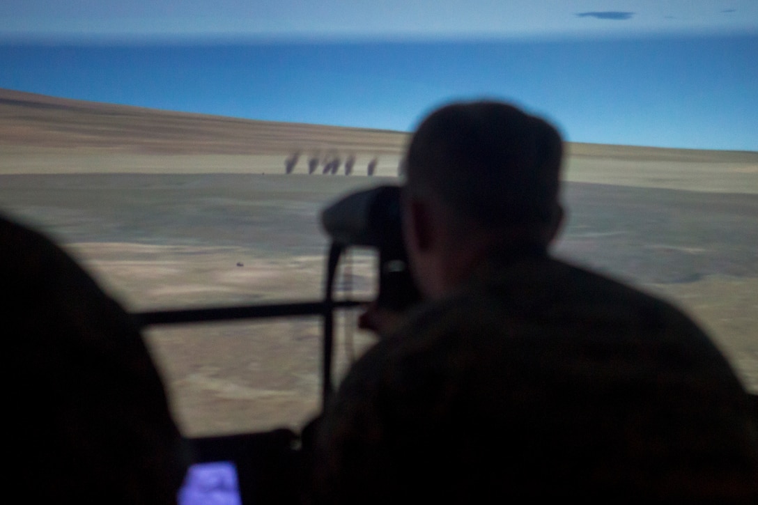 U.S. Marine Corps Cpl. Steven Mullener, a joint fire team observer with 1st Battalion, 12th Marine Regiment, observes a simulated attack on notional enemy forces on a Supporting Arms Virtual Trainer during Rim of the Pacific (RIMPAC) exercise on Marine Corps Base Hawaii June, 29, 2018. RIMPAC provides high-value training for task-organized, highly-capable Marine-Air Ground Task Force and enhances the critical crisis response capability of U.S. Marines in the Pacific.