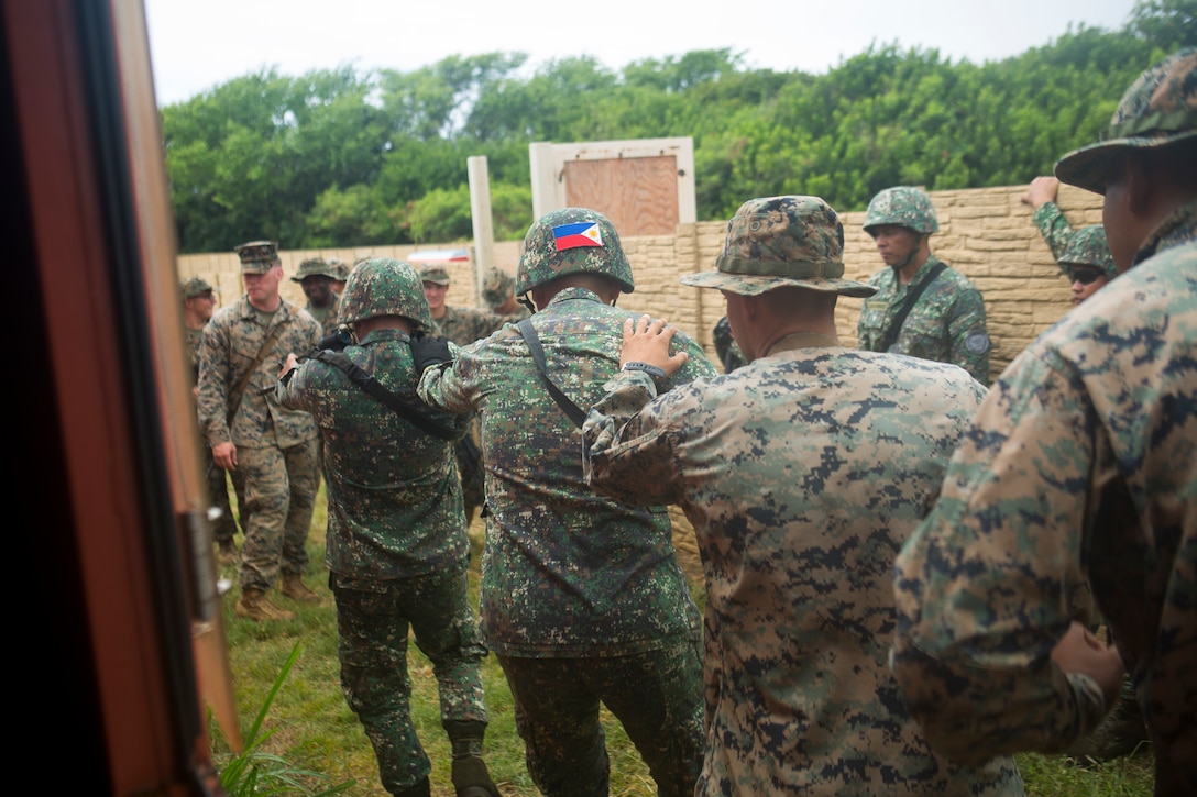 Philippine and U.S. Marines team up to clear a room during urban operations training as part of the Rim of the Pacific (RIMPAC) exercise aboard Marine Corps Base Hawaii June 28, 2018. Marines training with the U.S. Navy and partner nations from around the world enhances prowess. RIMPAC provides high-value training for task-organized, highly-capable Marine Air-Ground Task Force and enhances the critical crisis response capability of U.S. Marines in the Pacific. Twenty-five nations, more than 45 ships and submarines, about 200 aircraft, and 25,000 personnel are participating in RIMPAC from June 27 to Aug. 2 in and around the Hawaiian Islands and Southern California.