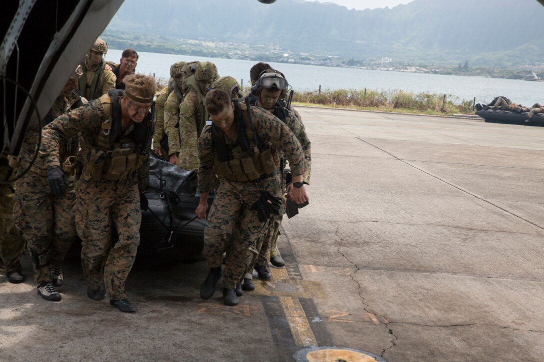 U.S. Marines with 3rd Reconnaissance Battalion and Australian soldiers with 2nd Battalion, Royal Australian Regiment, load a combat rubber raiding craft onto a CH-53E Super Stallion helicopter during amphibious operations as part of Rim of the Pacific (RIMPAC) exercise on Marine Corps Base Hawaii July 2, 2018. RIMPAC provides high-value training for task organized, highly-capable Marine Air-Ground Task Force and enhances the critical crisis response capability of U.S. Marines in the Pacific. Twenty-Five nations, more than 45 ships and submarines, about 200 aircraft, and 25,000 personnel are participating in RIMPAC from June 27 to Aug. 2 in and around the Hawaiian Islands and Southern California. (U.S. Marine Corps photo by Lance Cpl. Thomas P. Miller)