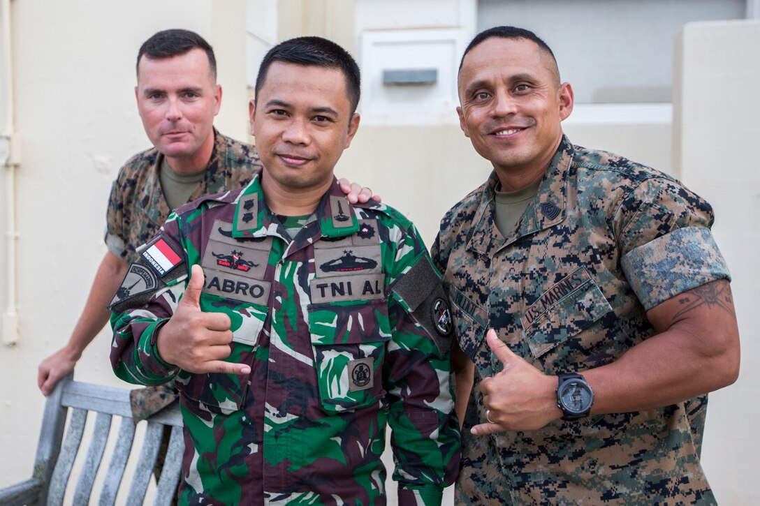 U.S. Marine Corps Sgt. Maj. Phillip Billiot, left, sergeant major, 3rd Marine Regiment, Indonesian Navy Lt. Cmdr. Sabro, and Sgt. Maj. Charlie Wells, sergeant major, Marine Corps Base Hawaii (MCBH), pose for a photo during a Marine Air-Ground Task Force (MAGTF) Hawaii social event as part of Rim of the Pacific (RIMPAC) exercise at MCBH July 2, 2018. MCBH senior leadership invited RIMPAC participants and community leaders to a dinner at the Officer’s Club. RIMPAC provides high-value training for task-organized, highly-capable MAGTF and enhances the critical crisis response capability of U.S. Marines in the Pacific. Twenty-five nations, 46 ships, five submarines, about 200 aircraft and 25,000 personnel are participating in RIMPAC from June 27 to Aug. 2 in and around the Hawaiian Islands and Southern California.