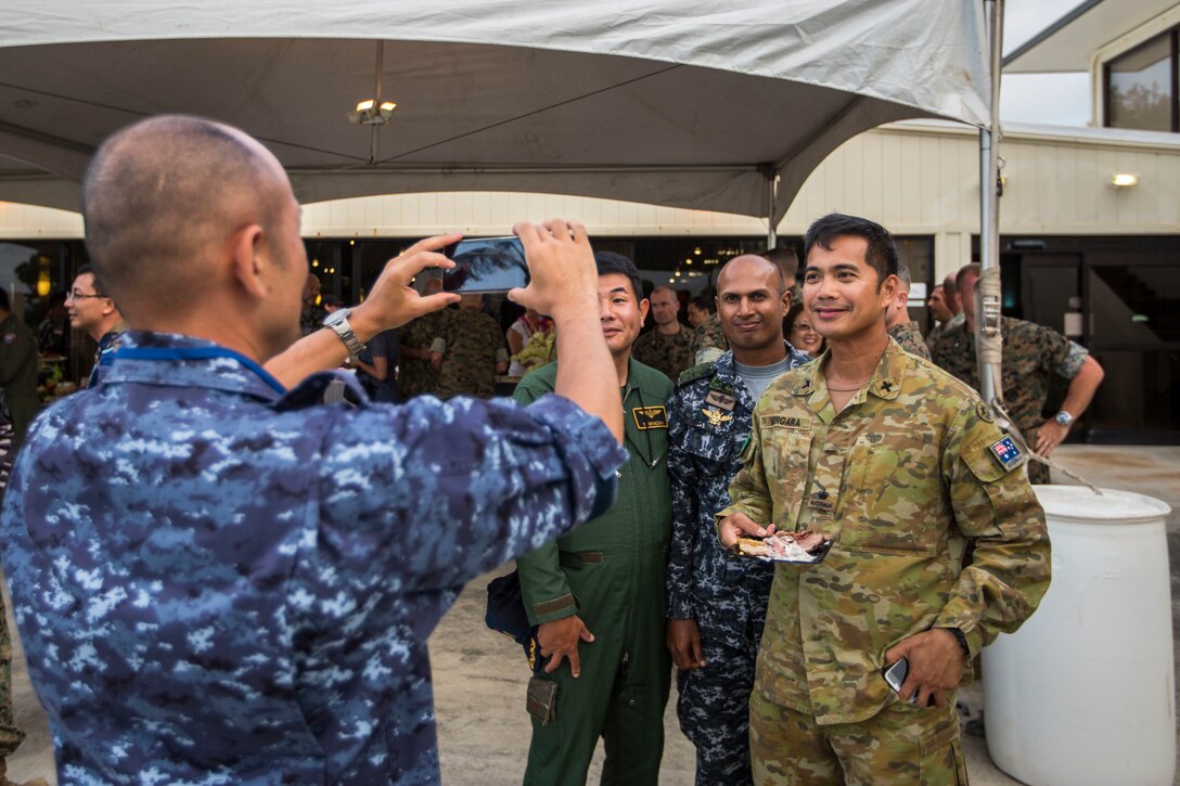 A Japanese sailor with Japan Maritime Self-Defense Force takes a picture of other military service members during a Marine Air-Ground Task Force (MAGTF) Hawaii social event as part of Rim of the Pacific (RIMPAC) exercise at Marine Corps Base Hawaii (MCBH) July 2, 2018. MCBH senior leadership invited RIMPAC participants and community leaders to a dinner at the Officer’s Club. RIMPAC provides high-value training for task-organized, highly-capable MAGTF and enhances the critical crisis response capability of U.S. Marines in the Pacific. Twenty-five nations, 46 ships, five submarines, about 200 aircraft and 25,000 personnel are participating in RIMPAC from June 27 to Aug. 2 in and around the Hawaiian Islands and Southern California.