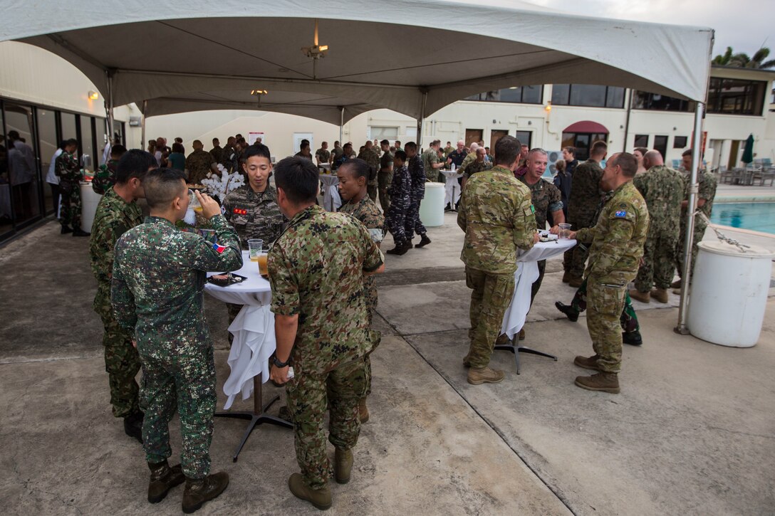 Various U.S. and foreign military service members speak to each other during a Marine Air-Ground Task Force (MAGTF) Hawaii social event as part of Rim of the Pacific (RIMPAC) exercise at Marine Corps Base Hawaii (MCBH) July 2, 2018. MCBH senior leadership invited RIMPAC participants and community leaders to a dinner at the Officer’s Club. RIMPAC provides high-value training for task-organized, highly-capable MAGTF and enhances the critical crisis response capability of U.S. Marines in the Pacific. Twenty-five nations, 46 ships, five submarines, about 200 aircraft and 25,000 are participating in RIMPAC from June 27 to Aug. 2 in and around the Hawaiian Islands and Southern California.