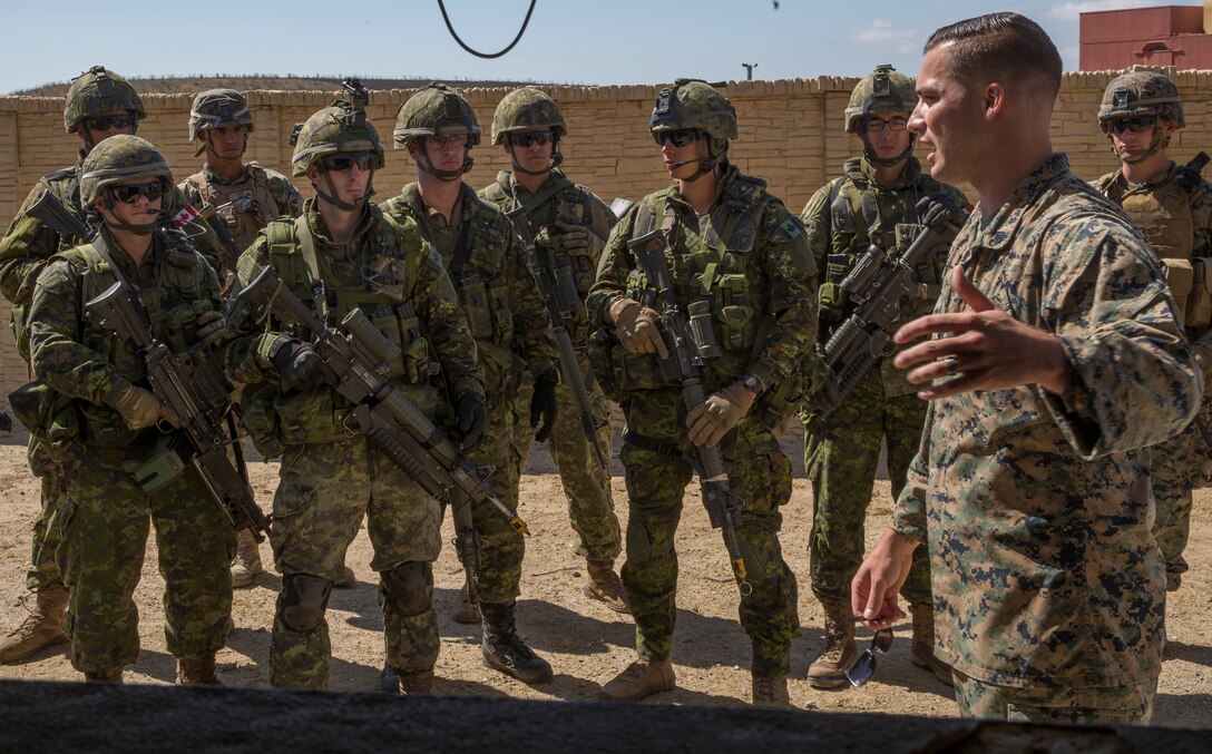 U.S. Marine Corps Sgt. Mark Salsbury Jr., right, a squad leader with 2nd Battalion, 1st Marine Regiment, provides feedback to services members during a combat-town drill as part of Rim of the Pacific (RIMPAC) exercise at Marine Corps Base Camp Pendleton, California, July 2, 2018. RIMPAC demonstrates the value of amphibious forces and provides high-value training for task-organized, highly-capable Marine Air-Ground Task Forces enhancing the critical crisis response capability of U.S. Marines in the Pacific. Twenty-five nations, 46 ships, five submarines, about 200 aircraft and 25,000 personnel are participating in RIMPAC from June 27 to Aug. 2 in and around the Hawaiian Islands and Southern California.