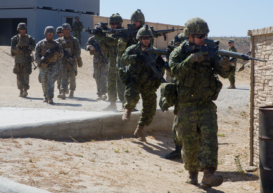 Canadian soldiers with Royal 22e Régiment advance through a combat town as part of Rim of the Pacific (RIMPAC) exercise at Marine Corps Base Camp Pendleton, California, July 2, 2018. RIMPAC demonstrates the value of amphibious forces and provides high-value training for task-organized, highly-capable Marine Air-Ground Task Forces enhancing the critical crisis response capability of U.S. Marines in the Pacific. Twenty-five nations, 46 ships, five submarines, about 200 aircraft and 25,000 personnel are participating in RIMPAC from June 27 to Aug. 2 in and around the Hawaiian Islands and Southern California.