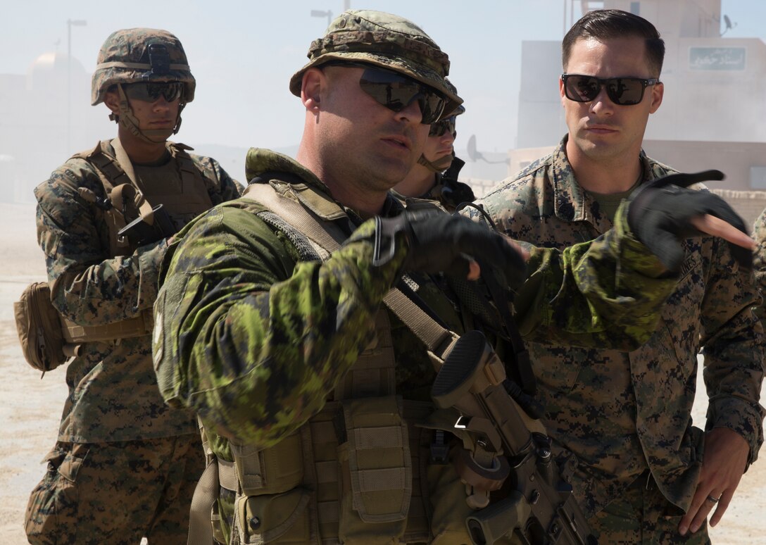 Canadian Army Sgt. Nicolas Gagnon, center, a diving section commander with Royal 22e Régiment, discusses various tactics with U.S. Marine Corps Sgt. Mark Salsbury Jr., a squad leader with 2nd Battalion, 1st Marine Regiment, during a combat-town drill as part of Rim of the Pacific (RIMPAC) exercise at Marine Corps Base Camp Pendleton, California, July 2, 2018. RIMPAC demonstrates the value of amphibious forces and provides high-value training for task-organized, highly-capable Marine Air-Ground Task Forces enhancing the critical crisis response capability of U.S. Marines in the Pacific. Twenty-five nations, 46 ships, five submarines, about 200 aircraft and 25,000 personnel are participating in RIMPAC from June 27 to Aug. 2 in and around the Hawaiian Islands and Southern California.